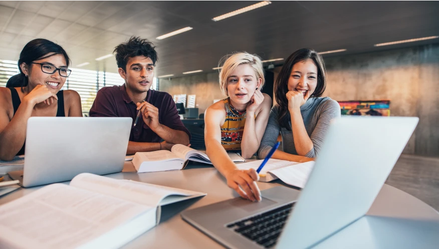 4 students in front of a laptop.