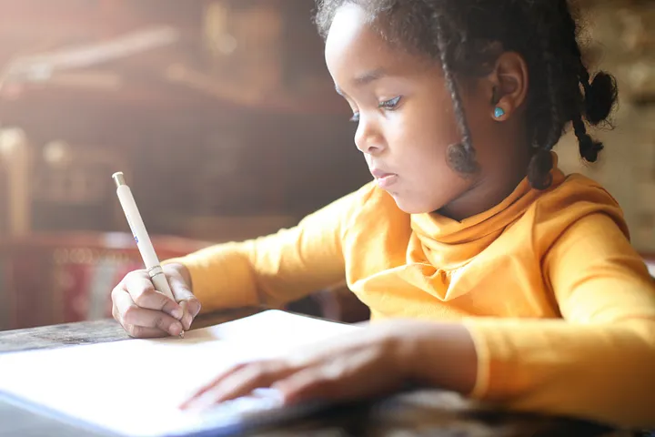 young student writing in notebook